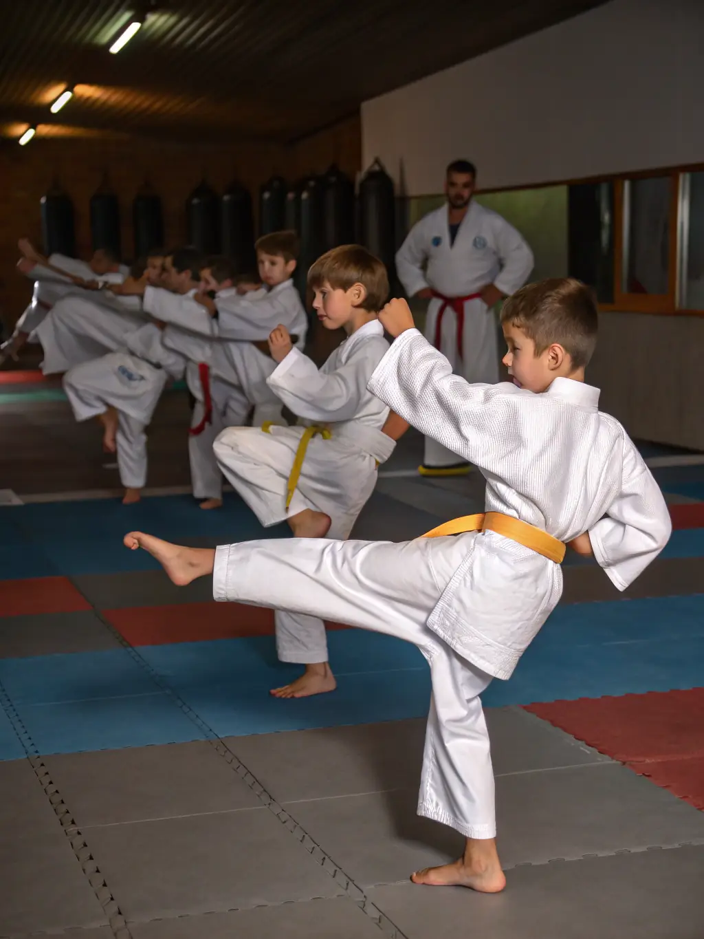 A focused image of young children in white karate uniforms practicing basic stances under the guidance of an instructor at KARATE IN LIVING LANDS, emphasizing discipline and foundational skills.